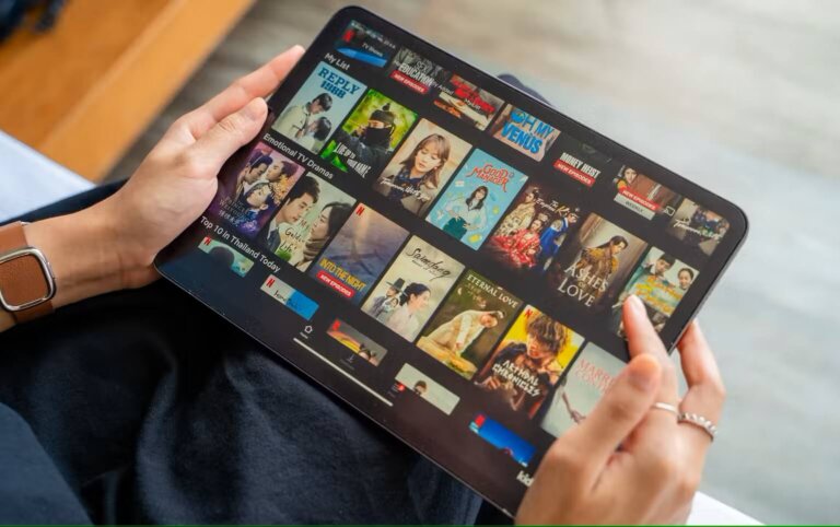 a woman holding an ipad browsing the netflix library